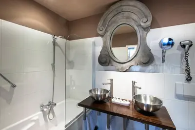 a bathroom with two sinks and a mirror at l'Auberge Damhotel in Edam