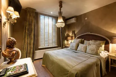 a bedroom with a bed and a large window at l'Auberge Damhotel in Edam