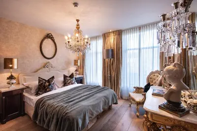 a bedroom with a bed and a child sitting in a chair at l'Auberge Damhotel in Edam