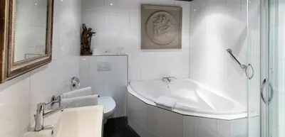 a white bathroom with a sink and a toilet at l'Auberge Damhotel in Edam