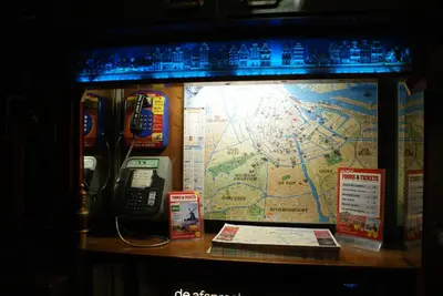 a phone and a map on a wall with a phone at Nadia Hotel in Amsterdam