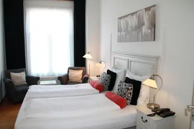 a bedroom with a large white bed with pillows at De Doelen in Leiden