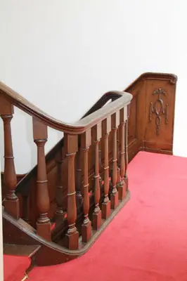a wooden staircase with a red carpet and a stair case at De Doelen in Leiden