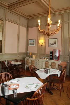 a dining room with tables and chairs and a chandelier at De Doelen in Leiden