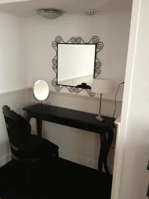 a desk with a mirror and a lamp and a chair at De Doelen in Leiden