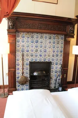a fireplace with blue and white tiles on a wall at De Doelen in Leiden