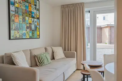 a living room with a couch and a table at Studio Becke, with private parking in Zandvoort