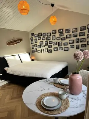 a bedroom with a bed and a table with plates and flowers at Have a nice stay! - Huisje bij Zee gratis parkeren in Noordwijk aan Zee