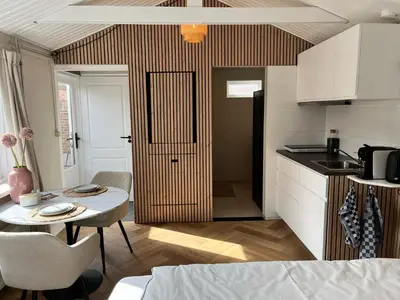 a kitchen with a table and a small kitchen with a door at Have a nice stay! - Huisje bij Zee gratis parkeren in Noordwijk aan Zee