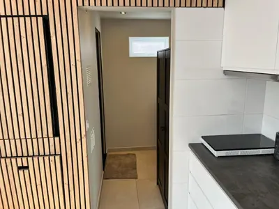 a kitchen with white walls and a door with a counter at Have a nice stay! - Huisje bij Zee gratis parkeren in Noordwijk aan Zee