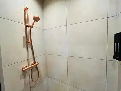 a shower in a bathroom with a shower head at Have a nice stay! - Huisje bij Zee gratis parkeren in Noordwijk aan Zee