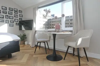 a room with a table and two chairs and a window at Have a nice stay! - Huisje bij Zee gratis parkeren in Noordwijk aan Zee