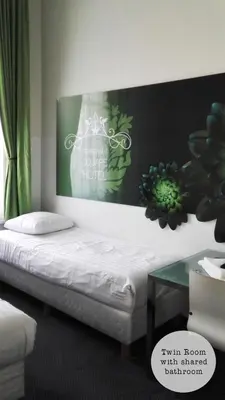 a bed in a room with a sign on the wall at Rembrandt Square Hotel in Amsterdam