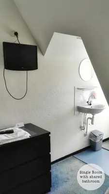 a bathroom with a bed and a sink in a room at Rembrandt Square Hotel in Amsterdam
