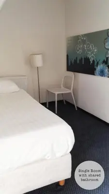 a hotel room with a bed and a chair at Rembrandt Square Hotel in Amsterdam