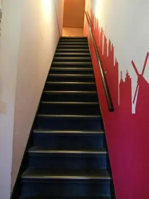 a staircase in a building with a red wall at Rembrandt Square Hotel in Amsterdam