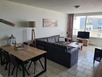 a living room with a couch and a table at Sterflat 151 in Egmond aan Zee