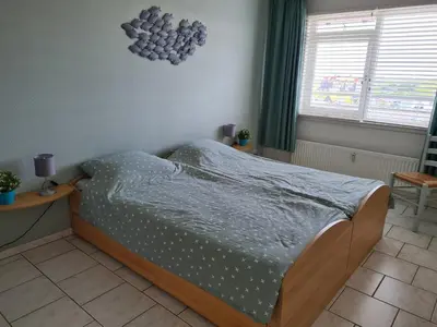 a bedroom with a bed with a blue comforter at Sterflat 151 in Egmond aan Zee