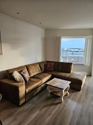 a living room with a brown couch and a table at Sterflat 157 in Egmond aan Zee