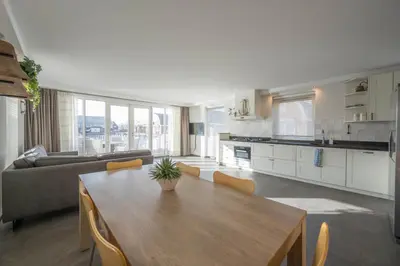 a kitchen and living room with a table and a couch at Meerzicht 71 - Perfectly suited for 6 persons in Uitgeest