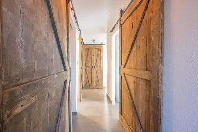 a hallway with wooden doors in a house at Meerzicht 71 - Perfectly suited for 6 persons in Uitgeest