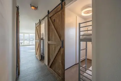 a sliding barn door in a room with a bunk bed at Meerzicht 71 - Perfectly suited for 6 persons in Uitgeest
