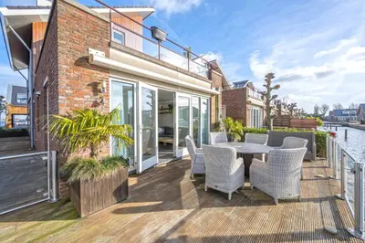 a patio with a table and chairs on a building at Meerzicht 71 - Perfectly suited for 6 persons in Uitgeest