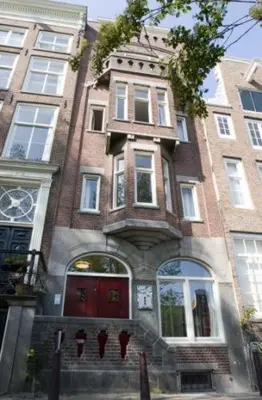 a large brick building with a red door at Prinsenhuis in Amsterdam