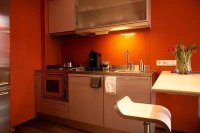 an orange kitchen with a sink and a microwave at Prinsenhuis in Amsterdam