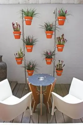 a table and two chairs and potted plants on a wall at Prinsenhuis in Amsterdam