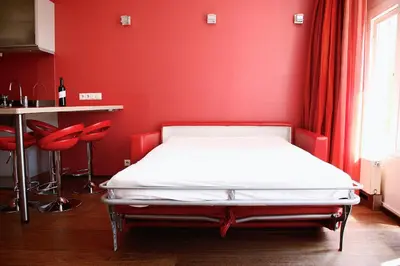 a bed in a room with a red wall at Prinsenhuis in Amsterdam