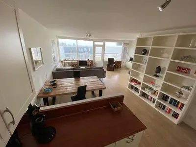 a living room with a table and a couch at Sterflat 173 in Egmond aan Zee