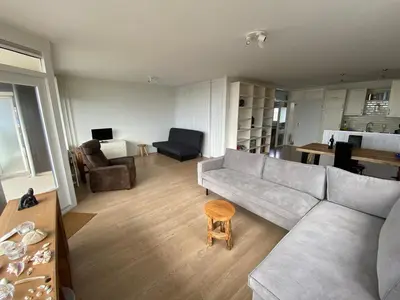 a living room with a couch and a table at Sterflat 173 in Egmond aan Zee