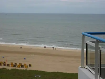 a view of a beach with chairs and the ocean at Sterflat 179 in Egmond aan Zee