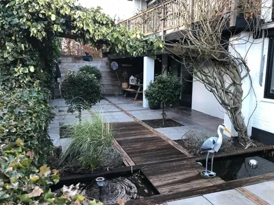 a garden with a swan on a wooden walkway at Villa Park in Bennebroek