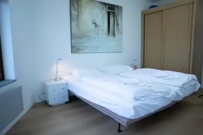 a bed in a bedroom with a picture on the wall at Sterflat 185 in Egmond aan Zee