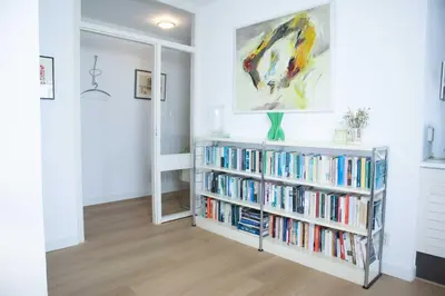 a room with a book shelf filled with books at Sterflat 185 in Egmond aan Zee