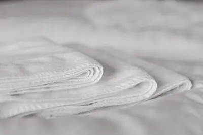 a stack of white towels sitting on a bed at Sterflat 185 in Egmond aan Zee