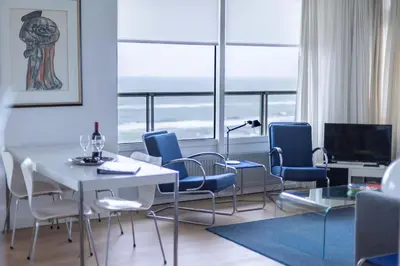a living room with a white table and chairs at Sterflat 185 in Egmond aan Zee