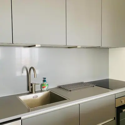 a kitchen with a sink and white cabinets at Sterflat 189 in Egmond aan Zee