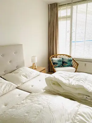 a bedroom with two beds and a window at Sterflat 189 in Egmond aan Zee
