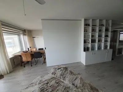 a white room with a large white closet and a table at Sterflat 199 in Egmond aan Zee