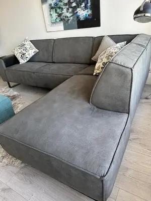 a couch with a large ottoman in a living room at Sterflat 199 in Egmond aan Zee