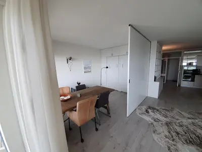 a dining room with a table and chairs at Sterflat 199 in Egmond aan Zee