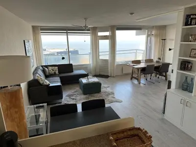 a living room with a couch and a table at Sterflat 199 in Egmond aan Zee