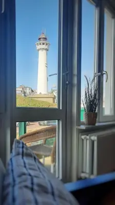 a view of a lighthouse from a window at Torenlicht in Egmond aan Zee