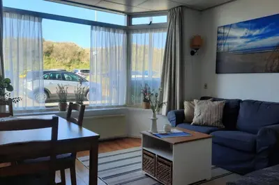 a living room with a blue couch and a table at Torenlicht in Egmond aan Zee