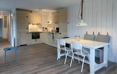 a kitchen and dining room with a white table and chairs at Gorgeous Apartment In Bergen Aan Zee in Bergen aan Zee