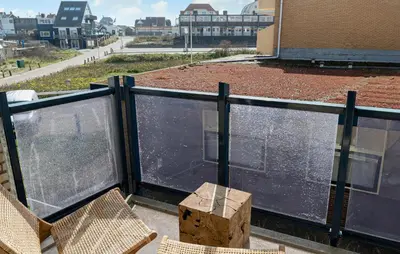 a balcony with two chairs and a table on a building at Gorgeous Apartment In Bergen Aan Zee in Bergen aan Zee