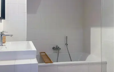 a bathroom with a bath tub and a sink at Gorgeous Apartment In Bergen Aan Zee in Bergen aan Zee